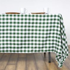 two cups are sitting on top of a green and white checkered tablecloth