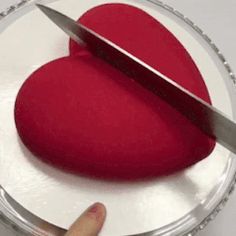 a heart shaped cake with a knife sticking out of it