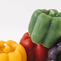 three different colored peppers on a white surface with one pepper still attached to the other