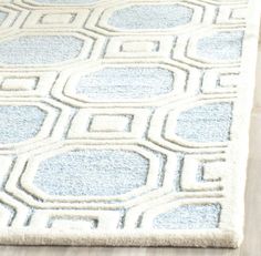 a blue and white area rug on a wooden floor