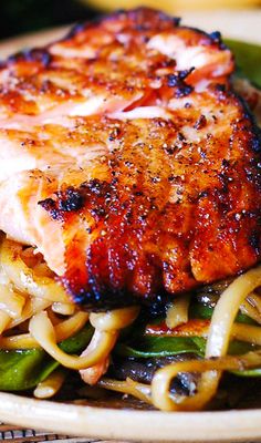 a close up of a plate of food with meat and noodles on it's side