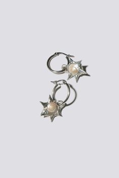 NOTE: This is a Pre-Order purchase. This piece is expected to ship Late January 2025. Small iridescent pearl colored ammonite fossil earrings encased with five silver-crafted spikes arranged in a star shape. Placed on surgical steel hoops. Sold as a pair. Silver Starburst Celestial Earrings, Fossil Earrings, Dear World, Iridescent Pearl, Striped Quilt, Norse Projects, Black Crane, Pearl Color, Star Shape