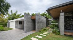 a modern house with stone walls and steps leading up to it