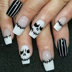 halloween nails with white and black designs on them