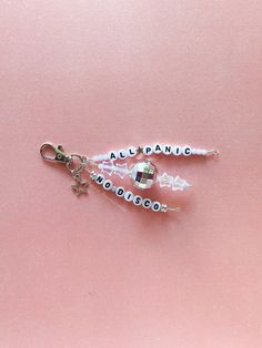 two charms with words on them sitting on a pink surface