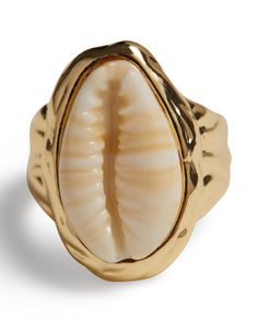 a gold ring with a shell in the middle and a wavy design on it's side