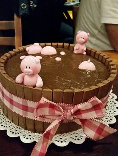 a cake decorated with pig figurines on top of a table