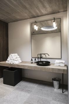 a bathroom with a sink, mirror and towel rack in it's center area