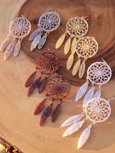 several dream catchers sitting on top of a piece of wood