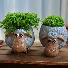 two ceramic sheep planters with plants in them