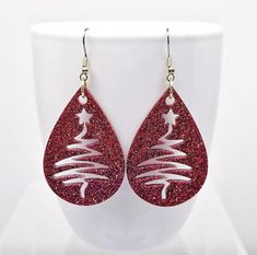 Christmas Tree cutout earrings created with crystal clear epoxy resin and classic Red glitter.  Finished with Stainless Steel fishhook ear wires with silicone backs.  Festive holiday earrings measure 2 3/4 inches long and 1 1/4 inches wide.   Celebrate the holidays in glamorous style with these super sparkly, fun earrings.  Makes the perfect Christmas gift for her, Secret Santa gift and a brilliant gift for you.  Why not treat yourself!?  🎁 Arrives in a gift box with bow, ready for giving. 🎁  📦  All orders are shipped via USPS with tracking. Santa Earrings Diy, Christmas Resin Jewelry, Christmas Leather Earrings, Diy Xmas Earrings, Leather Christmas Earrings, Holiday Party Earrings, Diy Christmas Earrings, Tree Cutout, Sister Christmas Gift