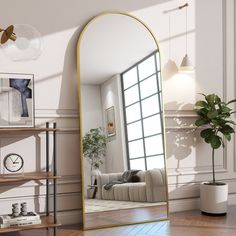 a large gold framed mirror sitting on top of a wooden floor