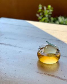 a glass bowl filled with liquid sitting on top of a wooden table