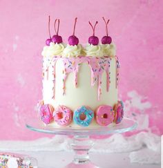 a birthday cake with donuts and sprinkles on it sitting on a plate