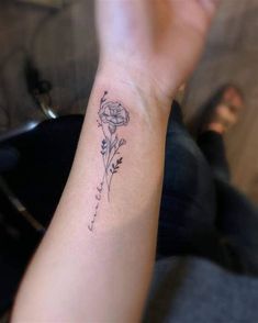 a woman's arm with a flower tattoo on it