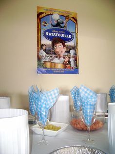 a table topped with plates and cups filled with food next to a sign that reads ratatouille