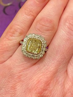 Gorgeous platinum and gold ring, centering a 3.01ct sqaure cushion-cut fancy yellow diamond set in 18k yellow gold bezel. Framed by two rows of round brilliant-cut diamonds totaling 1.12ct. 3.01ct t.w. Cushion-Cut Fancy Yellow Diamond 1.12ct t.w. Round Brilliant Cut Diamonds, G color VS clarity 18k yellow gold Platinum Formal Yellow Diamond Ring With Single Cut Diamonds, Formal Yellow Diamond Ring With Single Cut, Yellow Platinum Diamond Ring Fine Jewelry, Yellow Diamond Platinum Ring With Center Stone, Luxury Yellow Rings With Single Cut Diamonds, Fine Jewelry Yellow Diamond Platinum Ring, Yellow Cushion Cut Diamond Ring With Center Stone, Yellow Platinum Diamond Ring, Formal Yellow Cushion Cut Diamond Ring