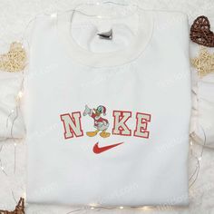 Introducing the Nike Christmas x Donald Duck Embroidered Sweatshirt, a festive masterpiece that combines the iconic charm of Donald Duck with the renowned quality of Nike. This limited edition sweatshirt is adorned with intricate embroidery, showcasing Donald Duck in a jolly Christmas scene. Crafted with premium materials, it offers unparalleled comfort and durability, making it [...] Nike Cartoon, Maroon Hoodie, Best Valentine's Day Gifts, Patrick Star, Hoodie Material, Custom Nikes, Embroidered Clothes, Embroidered Sweatshirt, Blue Sweatshirt