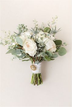 a bouquet of white flowers and greenery on a wall