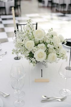 a centerpiece with white flowers on a table