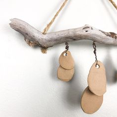 three wooden discs hanging from a branch