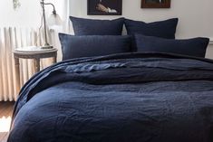 a bed with blue sheets and pillows in a room next to a radiator