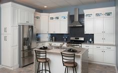 the kitchen is clean and ready to be used for cooking or baking, with two bar stools at the island