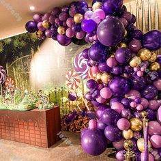 a room filled with lots of purple and gold balloons