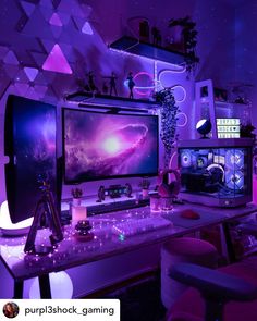 a computer desk with two monitors on it and purple lighting in the room behind it