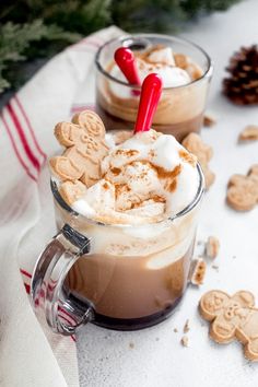 two cups filled with hot chocolate and marshmallows on top of a table