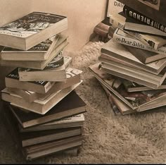 a pile of books sitting on top of a white rug