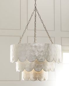 a chandelier hanging from a ceiling in a room with white walls and doors