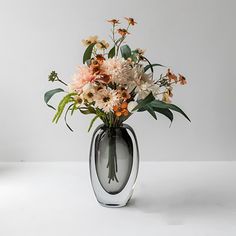 a vase filled with lots of flowers on top of a table