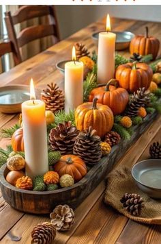 a wooden table topped with candles and pine cones