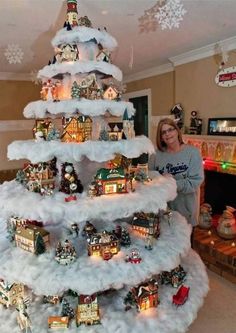 a woman standing in front of a christmas tree with snow on it's bottom