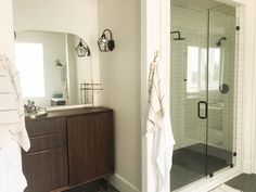 a bathroom with a sink, mirror and shower in it's center piece is shown