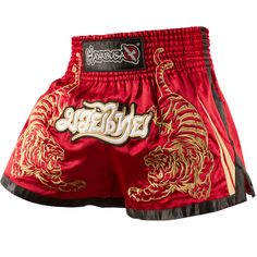 a red and gold boxing shorts with the word,'thai tiger'on it