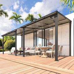 a covered patio with tables and chairs on the deck next to some palm trees in the background