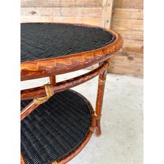 two tiered wooden table with black wicker and wood trimmings on the top