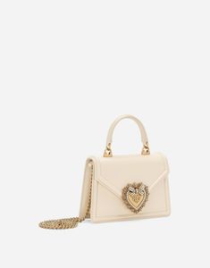 Small calfskin Devotion top-handle bag: Cream Front flap with bejeweled branded heart made from hand-tooled metal alloy with pearl inlay Concealed magnetic fastening and customized heart Top handle and detachable chain strap Calfskin interior with flat pocket Packaging matches the item Measurements: H13 x W19 x D4.5 cm Made in Italy Elegant Cream Bags, Luxury Shoulder Bag With Double Pearl Handle, Luxury Double Handle Shoulder Bag With Pearl, Elegant Cream Bag, Elegant Double Handle Bag With Pearl Detail, Elegant Double Handle Bag With Pearl Handle, Luxury Bag With Pearl Handle For Gift, Luxury Bags With Pearl Top Handle, Luxury Bags With Pearl Handle And Top Handle