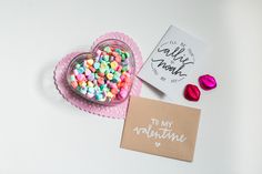 there is a card and some candy in the shape of a heart