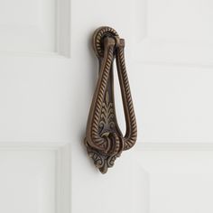 a door handle on the side of a white door with an ornate design in it