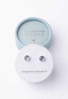 Our Lora silver opal studs shine with an array of dreamy lavender sparkle. The glistening iridescent color speaks of hope and a beautiful life transformed. These timeless stainless steel studs are a must in every collection! Available at an exclusive price in our beautifully paired ready-to-gift set! Her Favorite Studs Gift Set Box size and color may vary. Materials: White gold plated brass and artificial opal earrings with white gold plated brass earring posts. Hypoallergenic; lead and cadmium Starfish Project, Round Gift Boxes, Opal Gifts, Iridescent Color, A Beautiful Life, Opal Studs, Pretty Packaging, Stud Set, Jewel Box