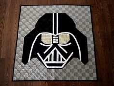 a darth vader quilted on the floor in front of a wooden floor