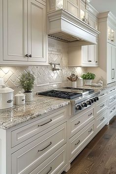 a large kitchen with white cabinets and marble counter tops, along with an oven in the center