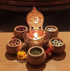 an assortment of small bowls with food in them on a table next to a candle