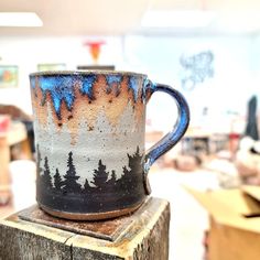 a coffee cup sitting on top of a wooden block