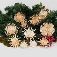 a group of wooden snowflakes sitting on top of a pile of pine needles