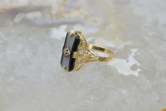 14K Yellow Gold Retro Onyx Filigree Ring, Diamond Center, .75 inch across, white & black stone, Ring size 7, 3.3 grams. Stock # BB101R15 Most rings are sizable for a small fee. If the ring you are considering is the incorrect size contact us for a quote. This listing contains photographs of the actual item you will receive. Our items are in excellent condition with little or no signs of wear and many are one of a kind pre-owned estate finds. Please look closely at the pictures in this listin Victorian Black Enamel Rings For Anniversary, Victorian Black Enamel Anniversary Rings, Polished Onyx Jewelry For Wedding, Wedding Onyx Jewelry With Polished Finish, Victorian Black Enamel Wedding Rings, Gold Onyx Rings For Wedding, Oval Black Enamel Wedding Rings, Gold Onyx Wedding Rings, Black Intaglio Jewelry As A Gift