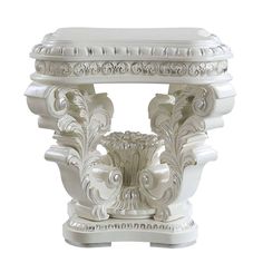 a white pedestal with an ornate design on top